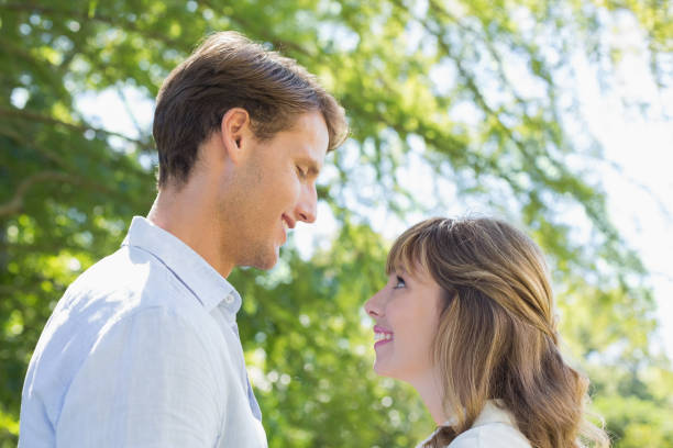 istock Attractive couple smiling at each other in the park 833494532