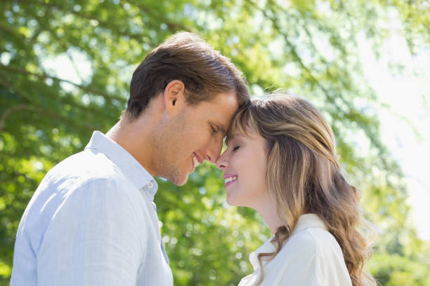 istock Attractive couple smiling at each other in the park 833494580