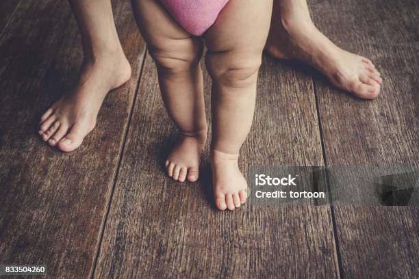 Happy Baby Learning To Walk With Mother Help Stock Photo - Download Image Now - Adult, Baby - Human Age, Foot