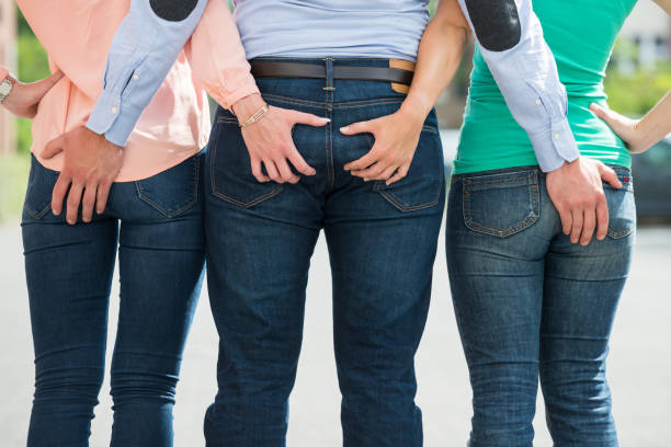 Friends Holding Each Other's Buttock Rear View Of Friends Holding Each Other's Buttock man touching womans buttock stock pictures, royalty-free photos & images
