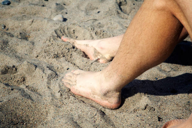 istock closeup of mans feet lying on the beach 833524630