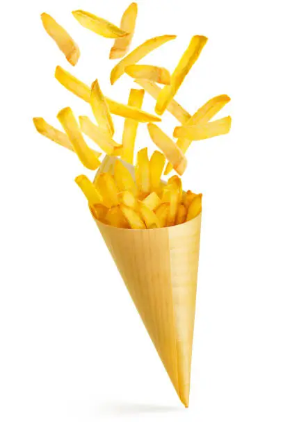 french fries spilling out a paper cone isolated on white