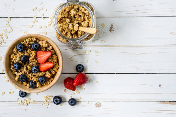istock Homemade granola and fresh berries on wood table with space. 833529288
