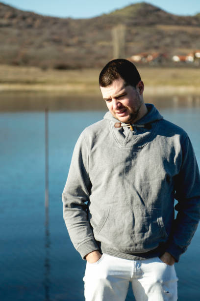 Young handsome man standing near lake