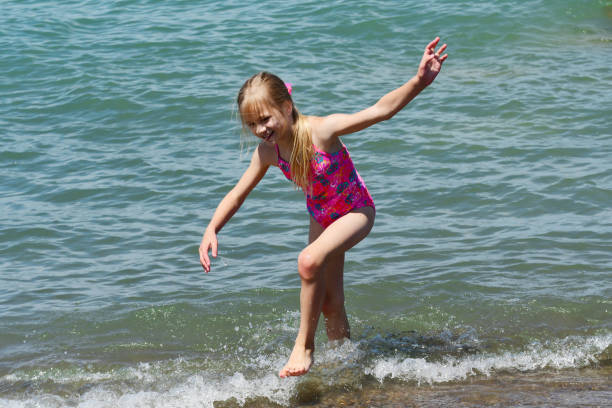 istock A Young Girl Plays at the Beach 833551120