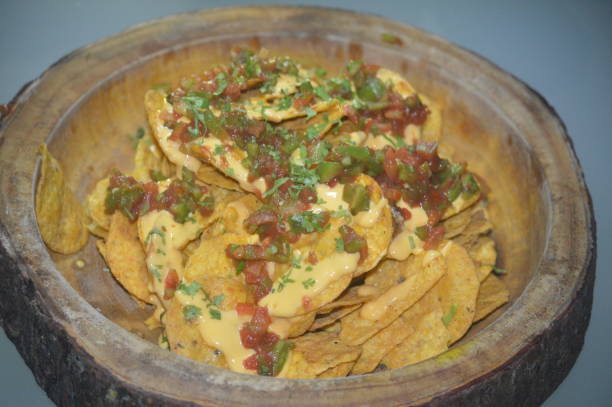 Tortilla chip with salsa sauce in wooden bowl