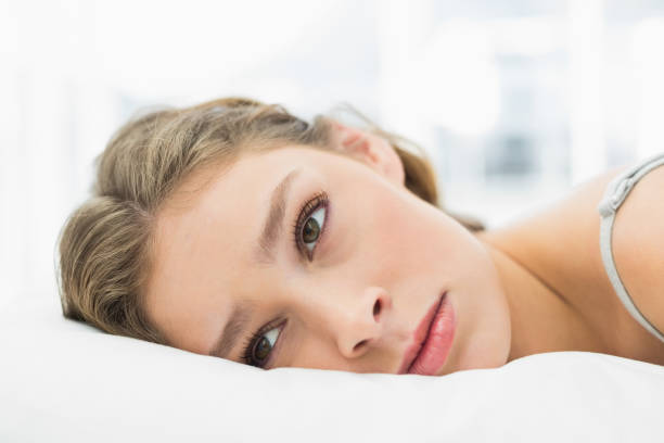istock Tired woman lying in her bed looking irritated 833582126