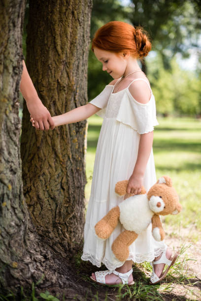 istock mother and daughter with teddy bear in park 833583116