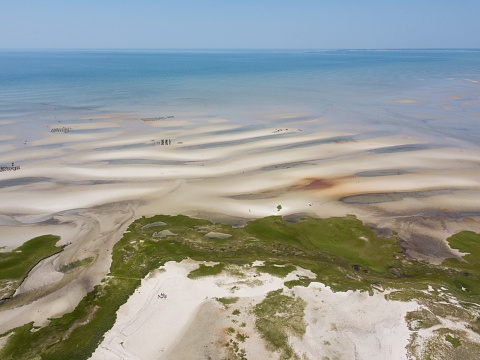 Low tide exposes a vast sand flat at a scenic beach on Cape Cod, Massachusetts. This sandy peninsula is a popular summer vacation destination and is also known for its many Great White sharks.