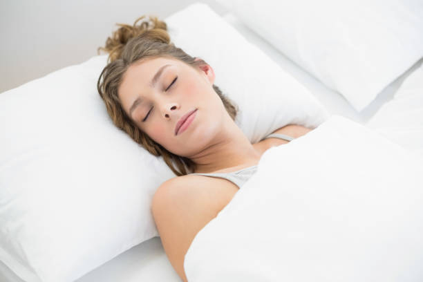 istock Calm young woman sleeping lying under the cover on her bed 833586444