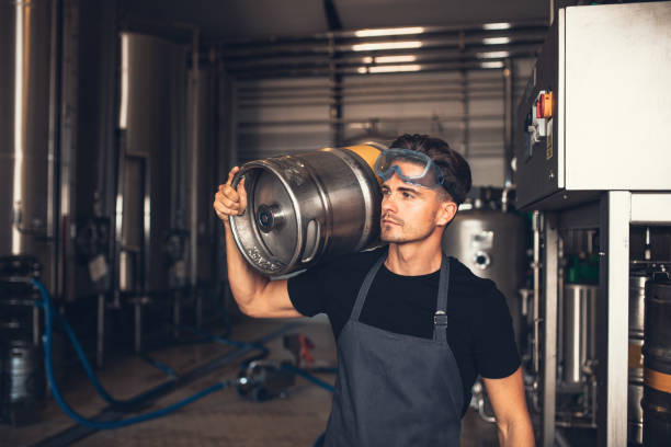 istock Brewer with large metal container at brewery factory 833598262