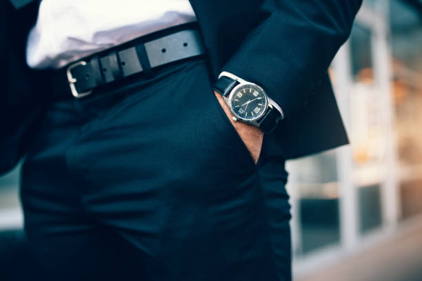 mano de hombre de negocios usando un reloj de bolsillo - manos en los bolsillos fotografías e imágenes de stock