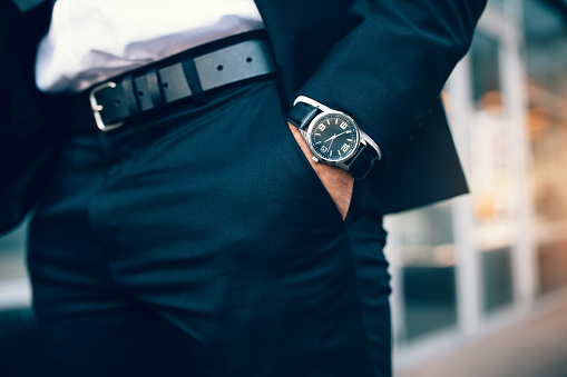 Close up of a business man's hand wearing a watch. Hand in pocket with wrist watch.