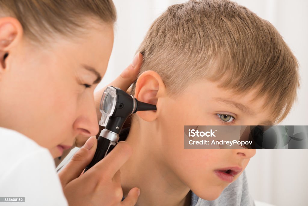 Doctor Examining Boy's Ear Close-up Of Female Doctor Examining Boy's Ear With An Otoscope Child Stock Photo