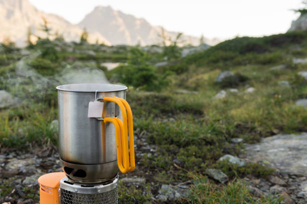 istock Campfire on mountain with tea container at dawn in summer outdoor 833619568