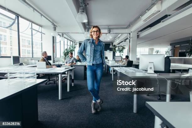 Young Businesswoman Standing In Office With Colleagues Stock Photo - Download Image Now