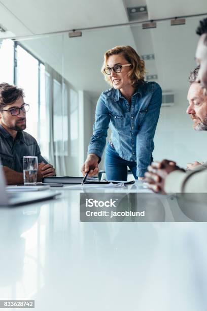 Businesswoman Presenting Her Ideas To Coworkers Stock Photo - Download Image Now - Meeting, Leadership, Women