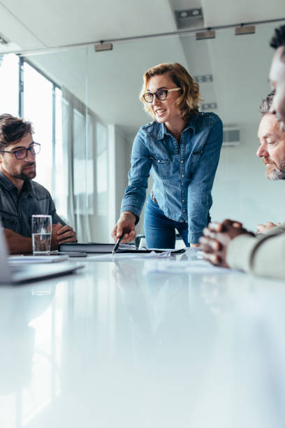 бизнесвумен представляет свои идеи коллегам - business person ceo board room office стоковые фото и изображения