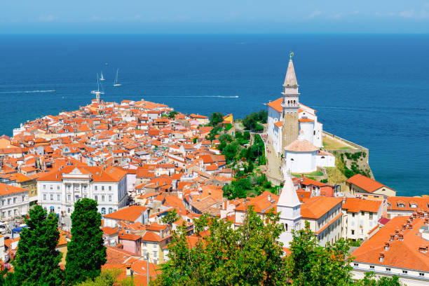 Piran, Slovenia. View from atop the city walls. Travel to Slovenia. Cityscape of Piran with historic buildings and church. Adriatic sea in the background. Panoramic picture. koper slovenia stock pictures, royalty-free photos & images
