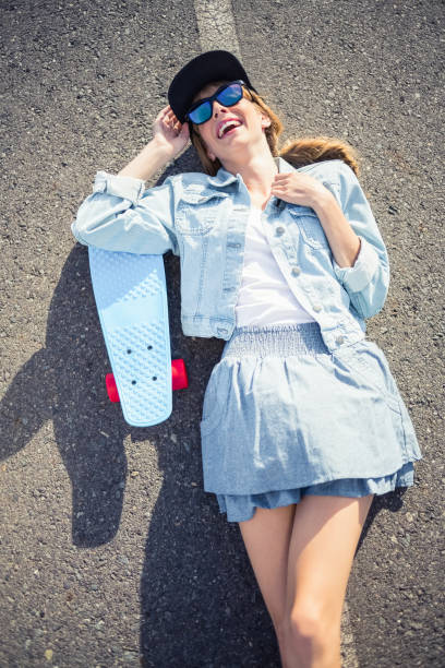 istock Smiling blonde skater lying on the highway 833629446