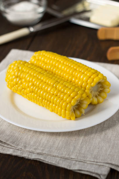 istock Homemade boiled corn on the wooden table. 833646550