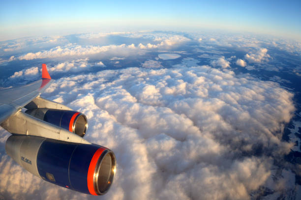 Airplane engine above  land mountains and clouds