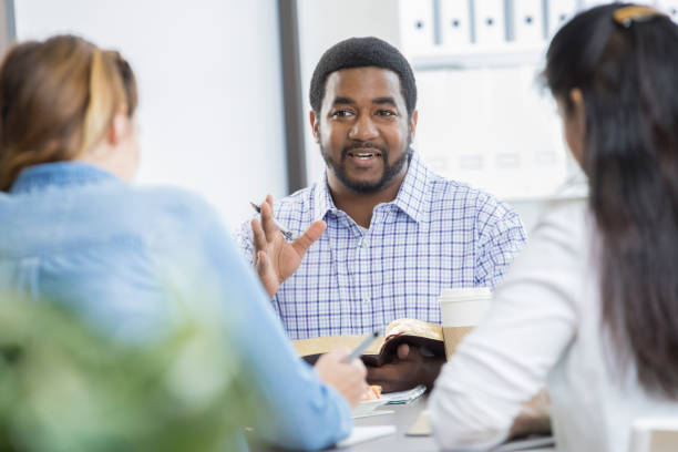 Confident businessman leads office Bible study during lunch