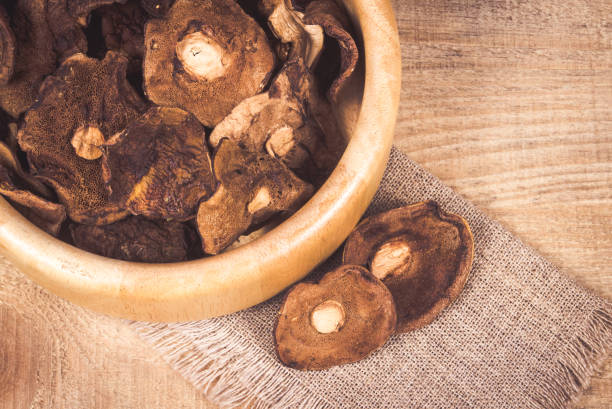 istock Dried forest mushrooms on a wooden table. 833683232