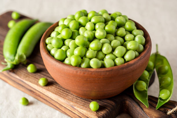 istock Fresh green peas in ceramic bowl on gray stone background 833686974