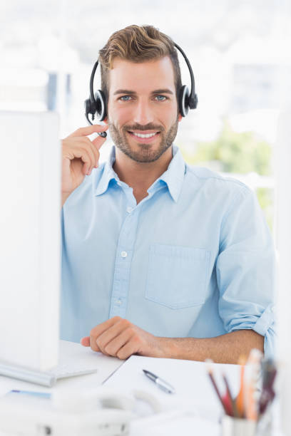 istock Portrait of a casual young man with headset using computer 833687262