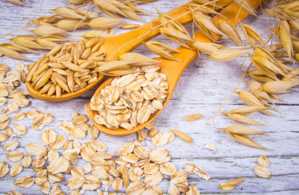 istock Raw oat flakes on a wooden table - closeup. 833697242