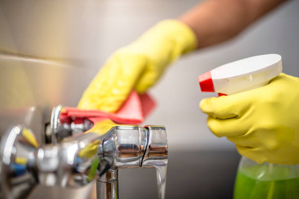 istock man wiping faucet in kitchen. 833728312