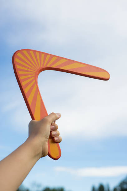 Boomerang in front of a blue sky Boomerang in front of a blue sky in woman hand boomerang stock pictures, royalty-free photos & images