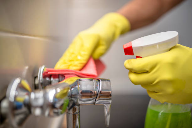 istock man wiping faucet in kitchen. 833738726