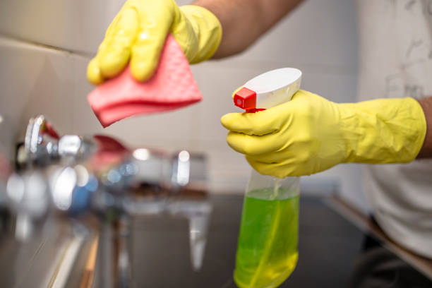 istock man wiping faucet in kitchen. 833739238