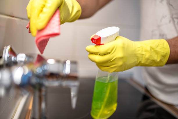 istock man wiping faucet in kitchen. 833739322