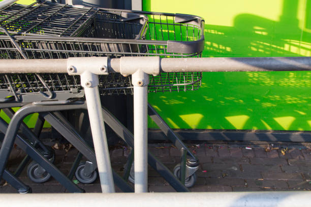 istock shopping carts in a line against green background 833741940