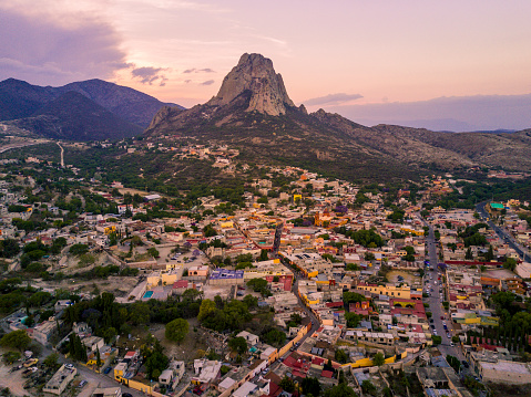 Peña de Bernal in Queretaro, Mexico. Big rock mountain with little town aerial.
