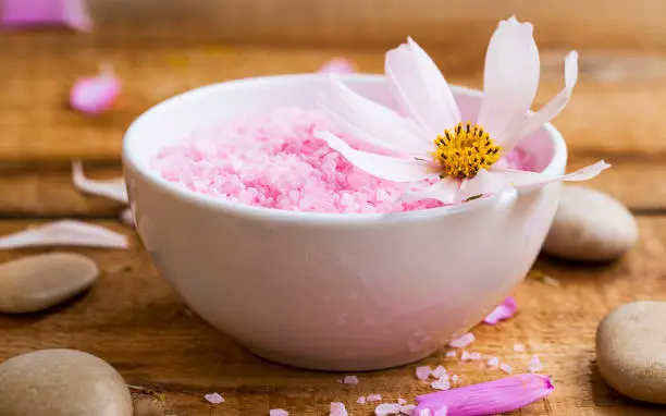 Spa bath salt bowl with flower.Pink bath salt wellness composition
