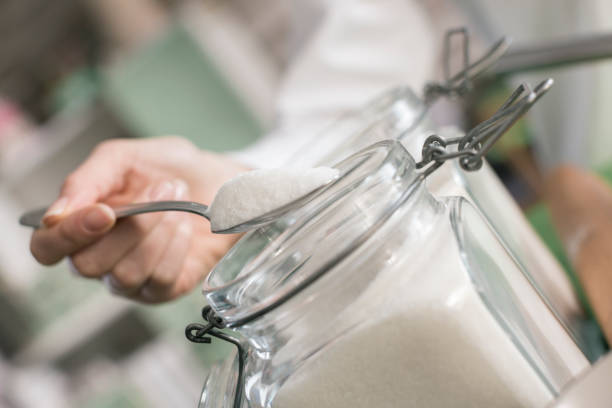 Close-up, woman hand taking sugar from jar stock photo