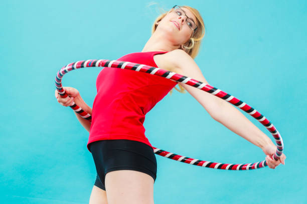 istock Fit woman with hula hoop doing exercise 833770928