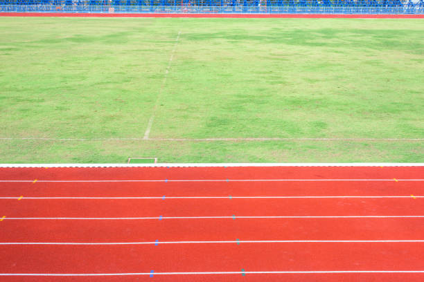 istock Red running track in stadium with field grass 833778840