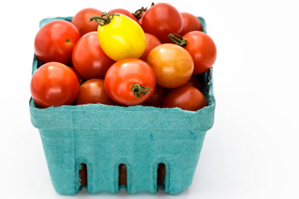 pinta de tomates cherry maduros en un cartón azul - heirloom tomato tomato vegetable fruit fotografías e imágenes de stock