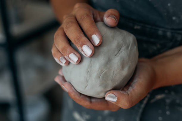 Potter is kneading clay, woman hands, working in pottery concept, selective focus