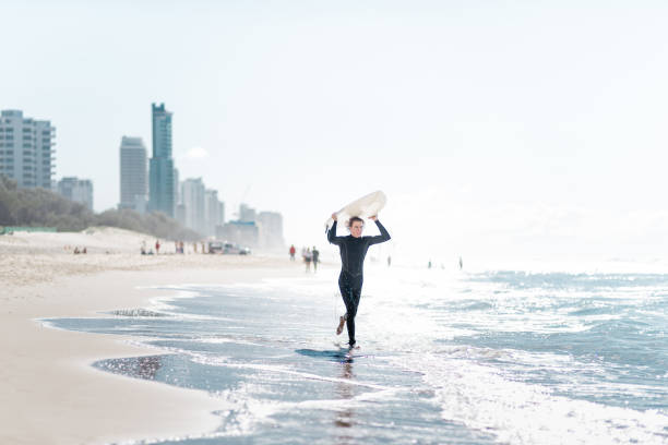 istock surfer walking in surfers paradise beach in australia 833804538
