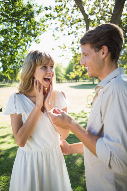 istock Man surprising his girlfriend with a proposal in the park 833822924