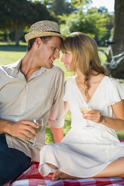 istock Cute couple drinking white wine on a picnic 833823524