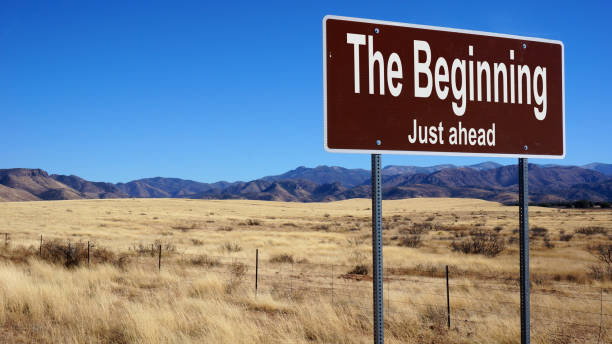 istock The Beginning brown road sign with blue sky 833845680
