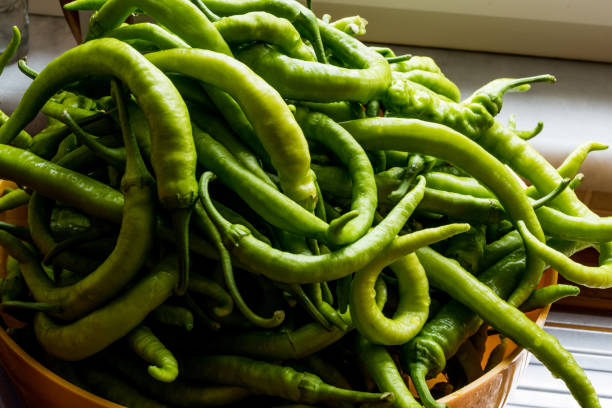 istock Green peppers in a yellow bowl at kitchen. 833858368