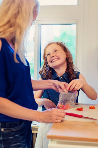 istock Mother and daughter making lunch on school morning. 833884800